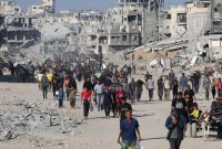 Ilustrasi. Warga Gaza berjalan di tengah puing-puing bangunan (Foto: REUTERS/Ebrahim Hajjaj)