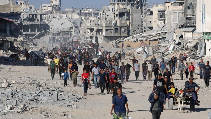 Ilustrasi. Warga Gaza berjalan di tengah puing-puing bangunan (Foto: REUTERS/Ebrahim Hajjaj)